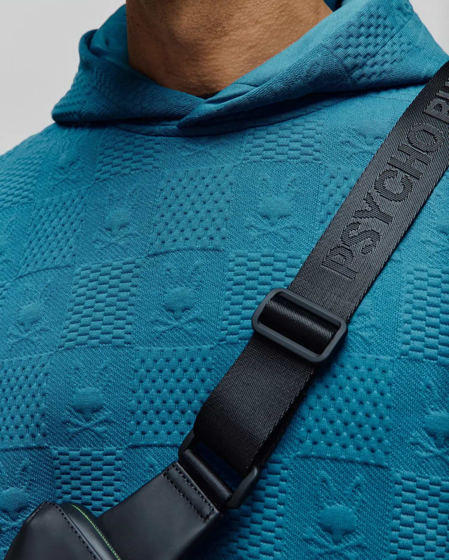 MENS DUSTIN HOODIE in vibrant teal, featuring a textured jacquard knit fabric with an all-over embossed Psycho Bunny skull and crossbones pattern, classic fit.