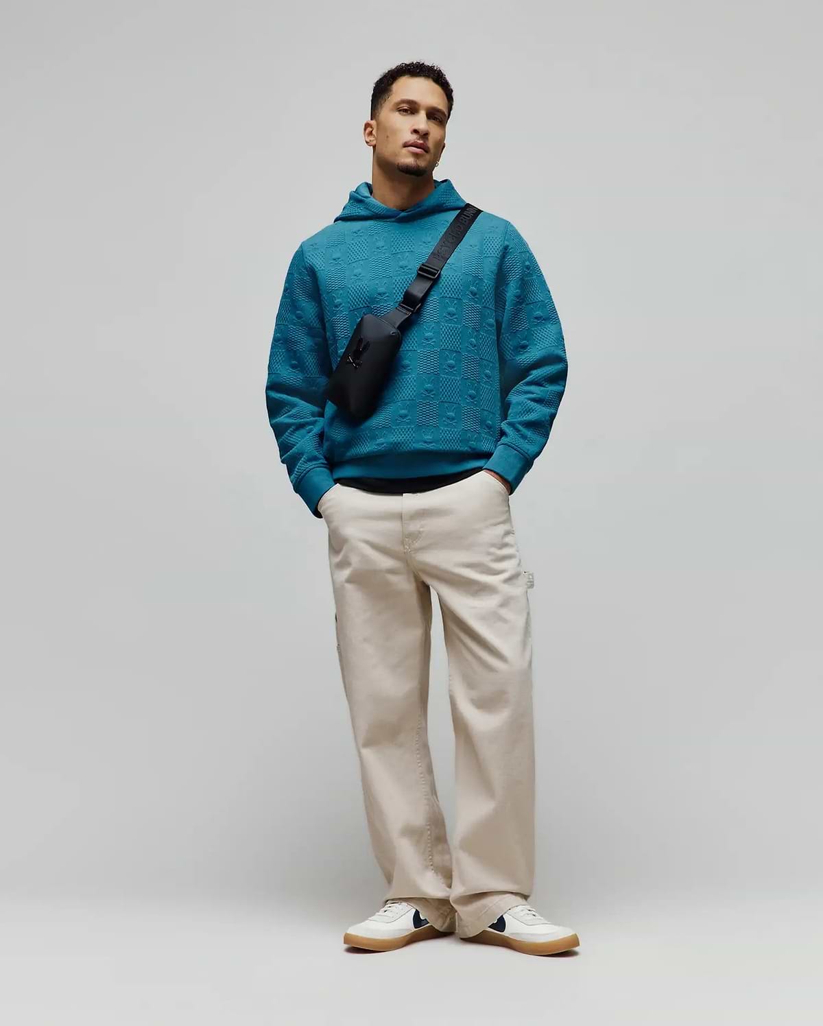 Vibrant teal Mens Dustin Hoodie, a relaxed fit, textured knit hoodie featuring an all-over embossed Psycho Bunny skull logo pattern for refined streetwear style.