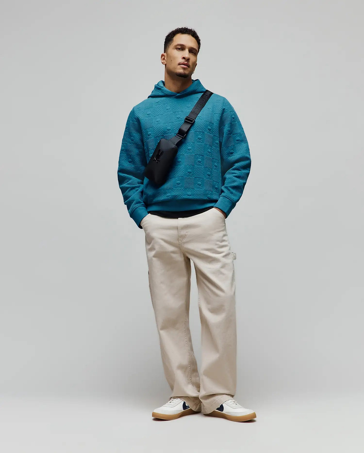 Vibrant teal Mens Dustin Hoodie, a relaxed fit, textured knit hoodie featuring an all-over embossed Psycho Bunny skull logo pattern for refined streetwear style.