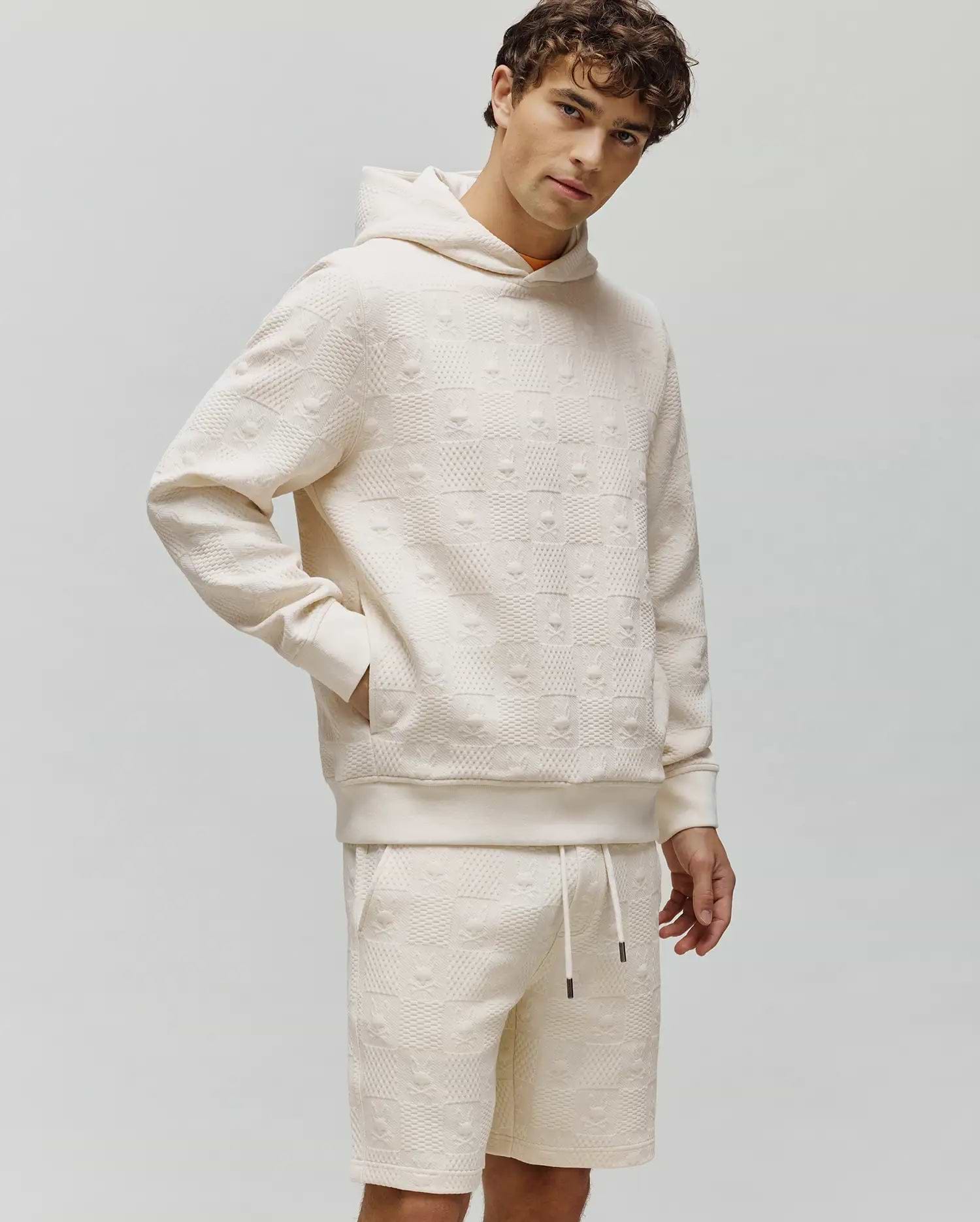 Cream Mens Dustin Hoodie and matching shorts in a relaxed fit, featuring an all-over embossed Psycho Bunny skull and checkerboard textured knit pattern.