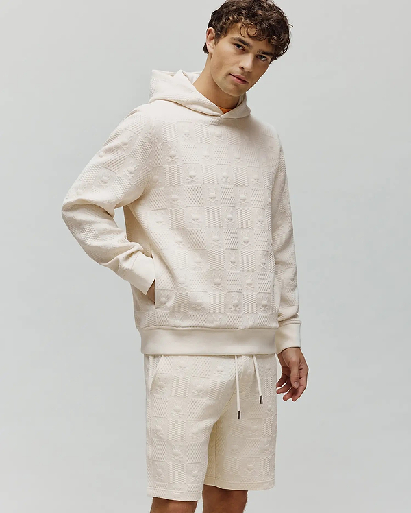 Cream Mens Dustin Hoodie and matching shorts in a relaxed fit, featuring an all-over embossed Psycho Bunny skull and checkerboard textured knit pattern.