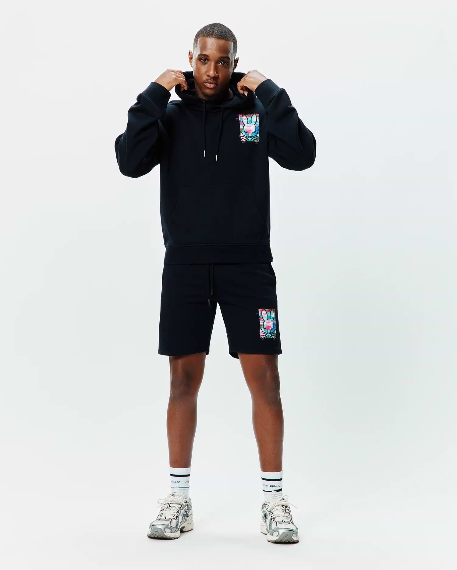 Black relaxed fit French terry hoodie and shorts set featuring a vibrant Psycho Bunny skull logo print on the left chest and left thigh, with drawstrings and a kangaroo pocket. Mens Isaac Print Hoodie.