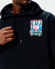 Mens Isaac Print Hoodie, a black relaxed-fit french terry hoodie featuring a large chest print of the iconic Psycho Bunny skull logo over a vibrant, distressed multicolored background.