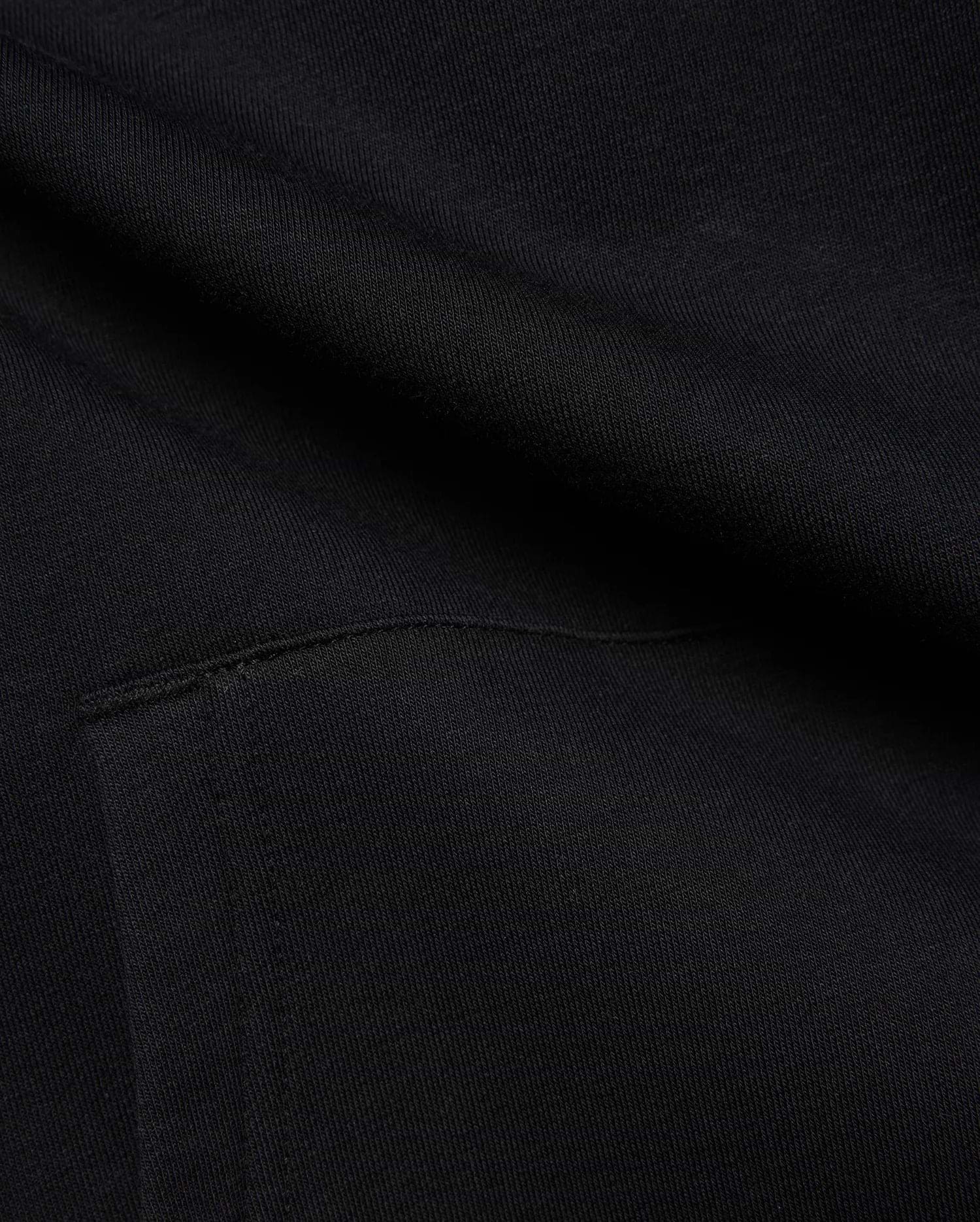 Black MENS ISAAC PRINT HOODIE in soft French terry knit, featuring subtle diagonal texture and a visible seam detail, hinting at a signature Psycho Bunny graphic print.