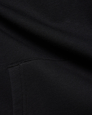 Black MENS ISAAC PRINT HOODIE in soft French terry knit, featuring subtle diagonal texture and a visible seam detail, hinting at a signature Psycho Bunny graphic print.