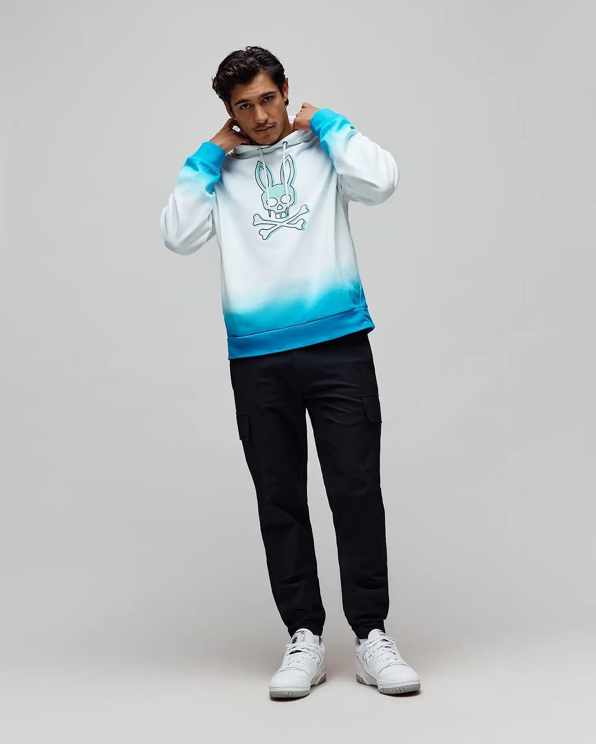 Mens Dax Oversized Hoodie, a white to vibrant blue ombre soft jersey hoodie featuring a large central blue Psycho Bunny skull and crossbones graphic. (4)
