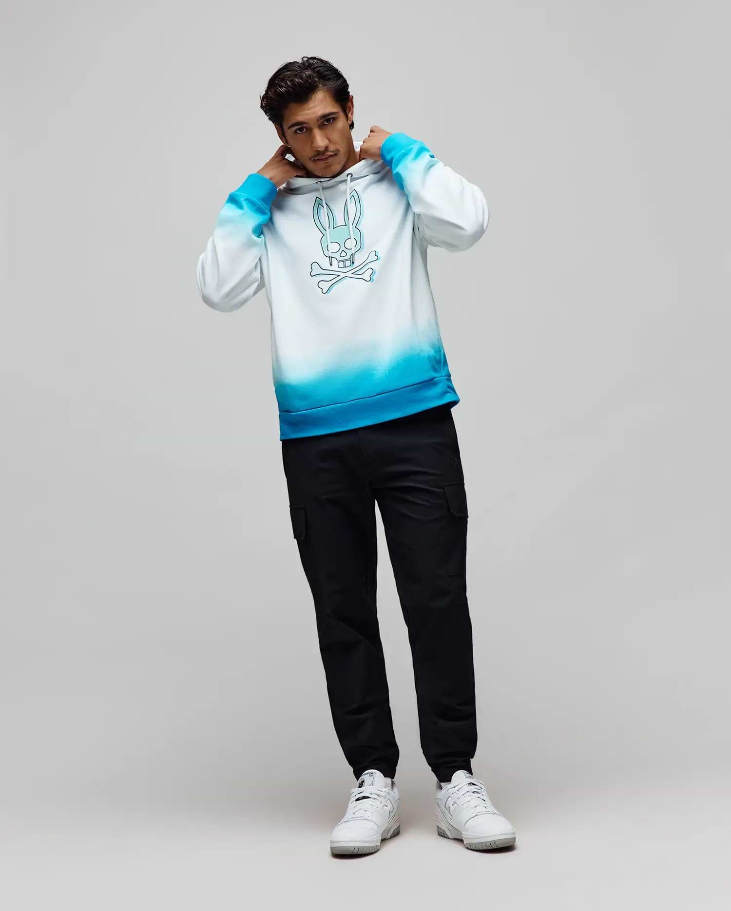 Mens Dax Oversized Hoodie, a white to vibrant blue ombre soft jersey hoodie featuring a large central blue Psycho Bunny skull and crossbones graphic. (4)