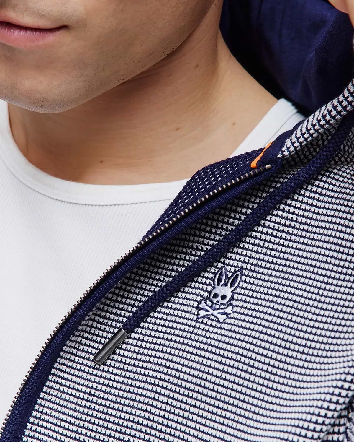 Mens Maxton Waffle Full Zip Hoodie in navy and white waffle knit, featuring a full zip closure with an orange accent, navy drawstrings, and a small embroidered Psycho Bunny skull logo on the chest.