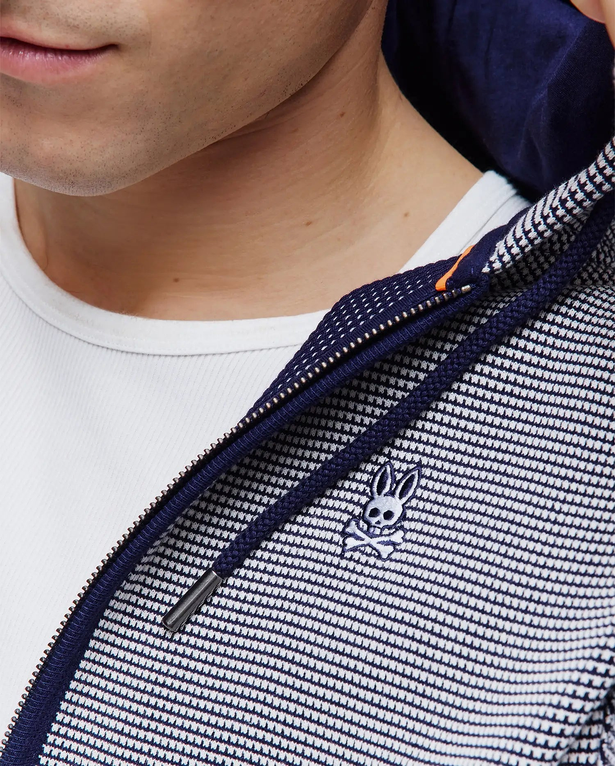 Mens Maxton Waffle Full Zip Hoodie in navy and white waffle knit, featuring a full zip closure with an orange accent, navy drawstrings, and a small embroidered Psycho Bunny skull logo on the chest.