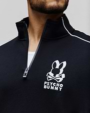 Mens Toby 1/4 Zip, a black classic fit smooth knit pullover with a stand-up collar, white shoulder piping, and a large white embroidered Psycho Bunny skull logo on the left chest, featuring a branded zipper pull.