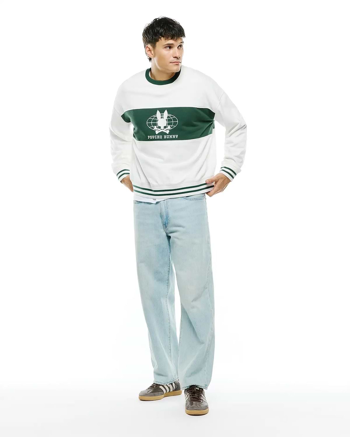 Mens Mike French Terry Crew. White relaxed-fit sweatshirt with a wide green chest stripe featuring a large white Psycho Bunny skull globe logo and text, plus green ribbed trim with white stripes.