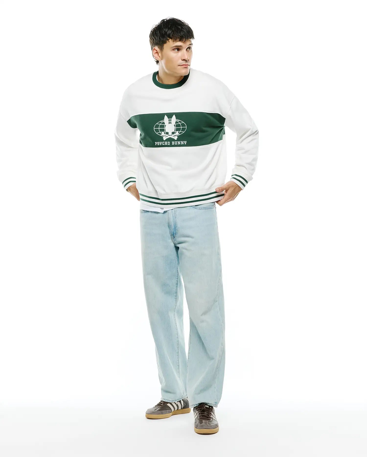 Mens Mike French Terry Crew. White relaxed-fit sweatshirt with a wide green chest stripe featuring a large white Psycho Bunny skull globe logo and text, plus green ribbed trim with white stripes.