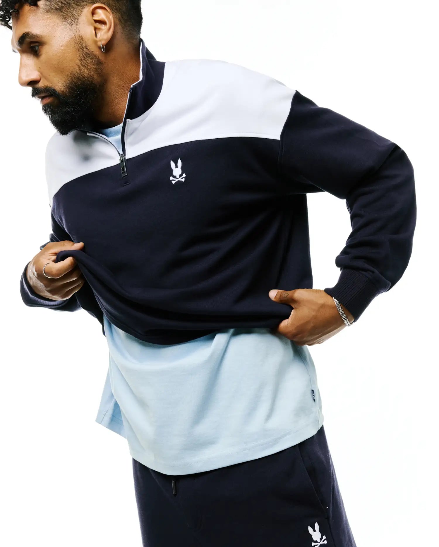 Mens Gabe French Terry 1/4 Zip in a classic fit, featuring a navy and white color block design, stand-up collar, and a small embroidered white Psycho Bunny skull logo on the left chest.
