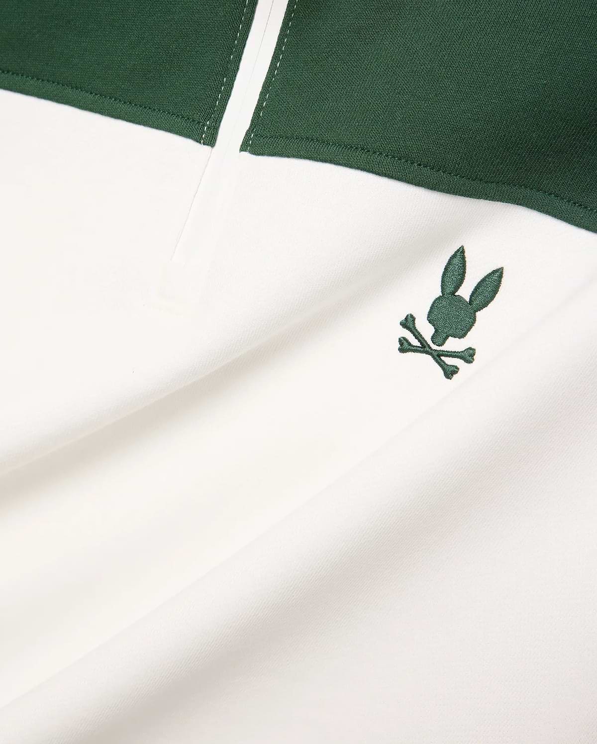 Mens Gabe French Terry 1/4 Zip, a white and dark green color-block design with a small, embroidered dark green Psycho Bunny skull logo on the chest. Soft French terry fabric.