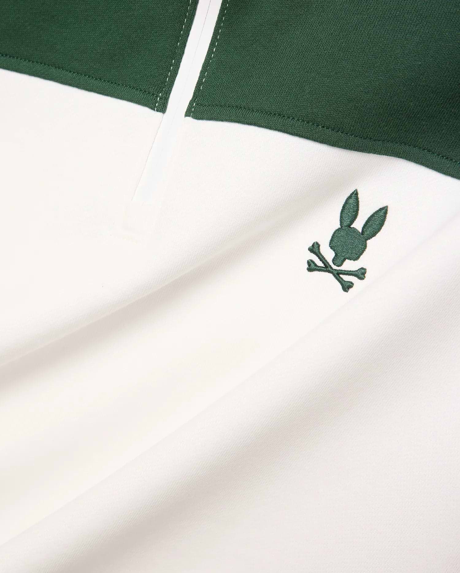 Mens Gabe French Terry 1/4 Zip, a white and dark green color-block design with a small, embroidered dark green Psycho Bunny skull logo on the chest. Soft French terry fabric.