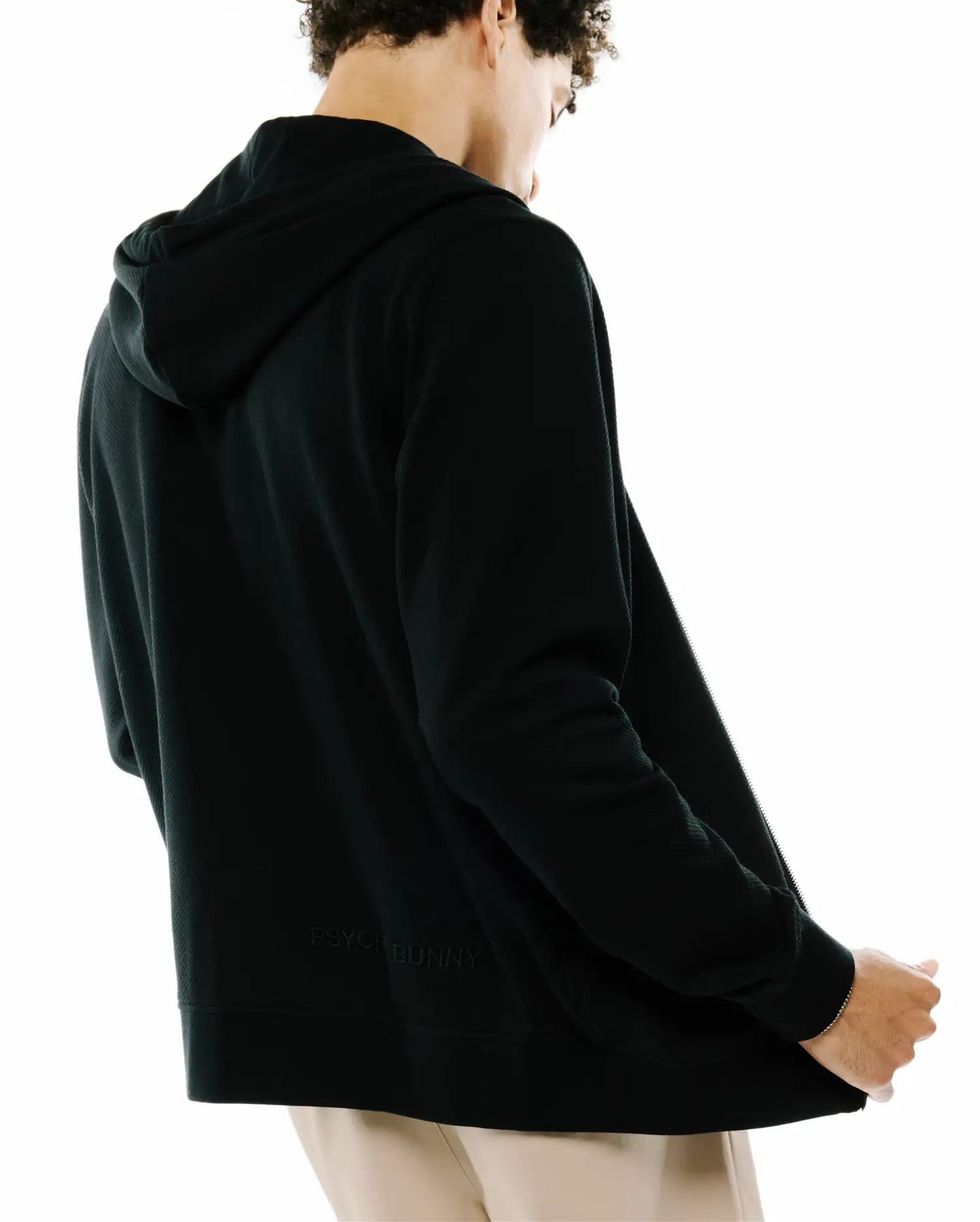 Mens Marc Textured Full Zip Hoodie in black, featuring a subtle textured fabric, full-zip closure, and a tone-on-tone embroidered PSYCHO BUNNY text logo on the lower back.