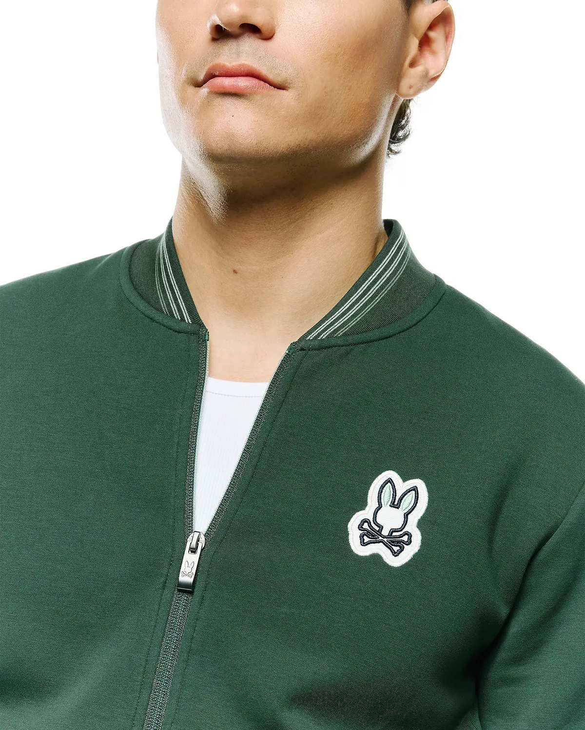Mens Jaydon Track Jacket, forest green, smooth knit, full-zip with Psycho Bunny logo pull, embroidered white/light green bunny skull logo on left chest, and striped ribbed collar. (4)
