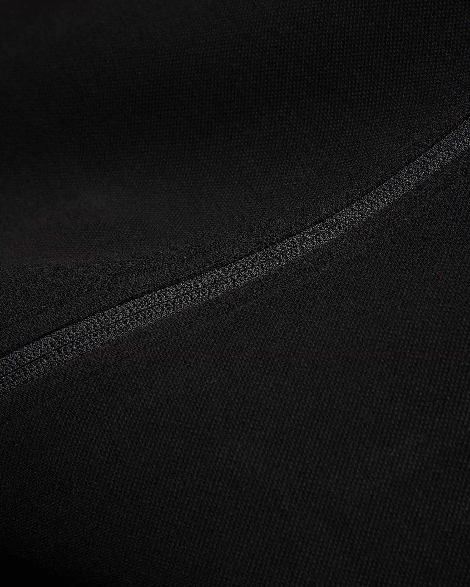 Black Mens Ceano Track Jacket featuring a smooth, finely textured knit fabric, accented by a prominent, precisely stitched flatlock seam running diagonally across the garment.