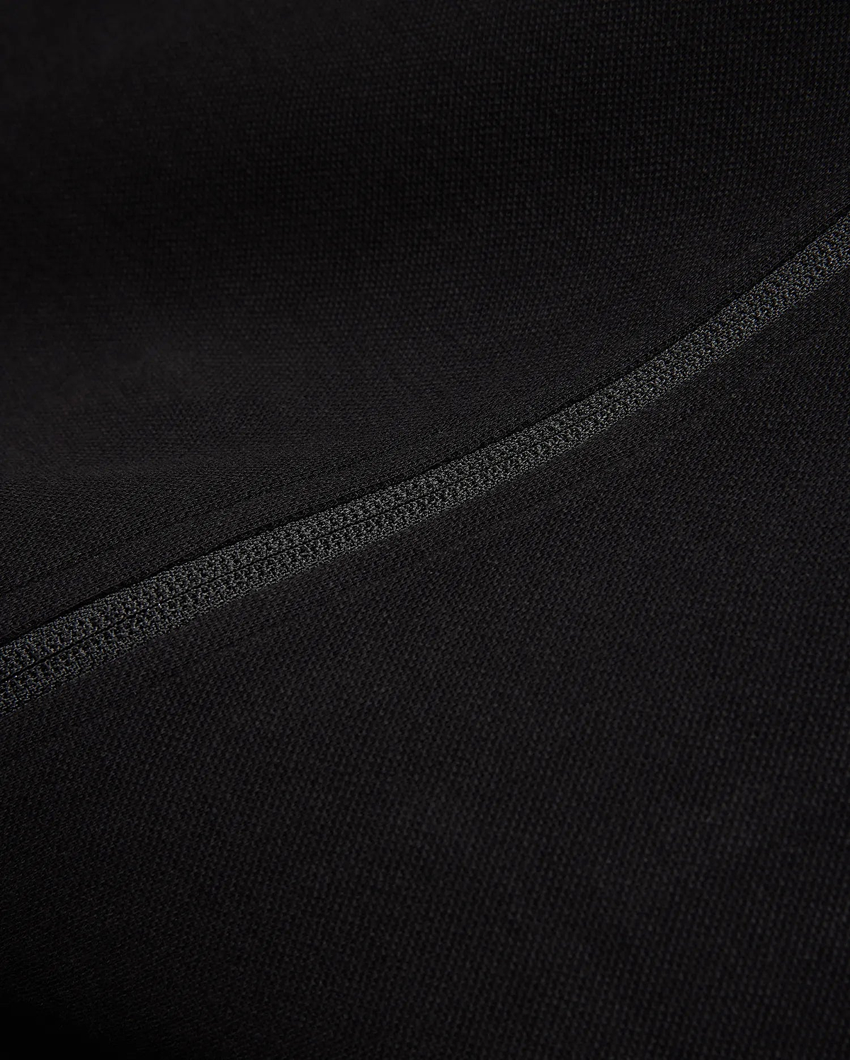 Black Mens Ceano Track Jacket featuring a smooth, finely textured knit fabric, accented by a prominent, precisely stitched flatlock seam running diagonally across the garment.