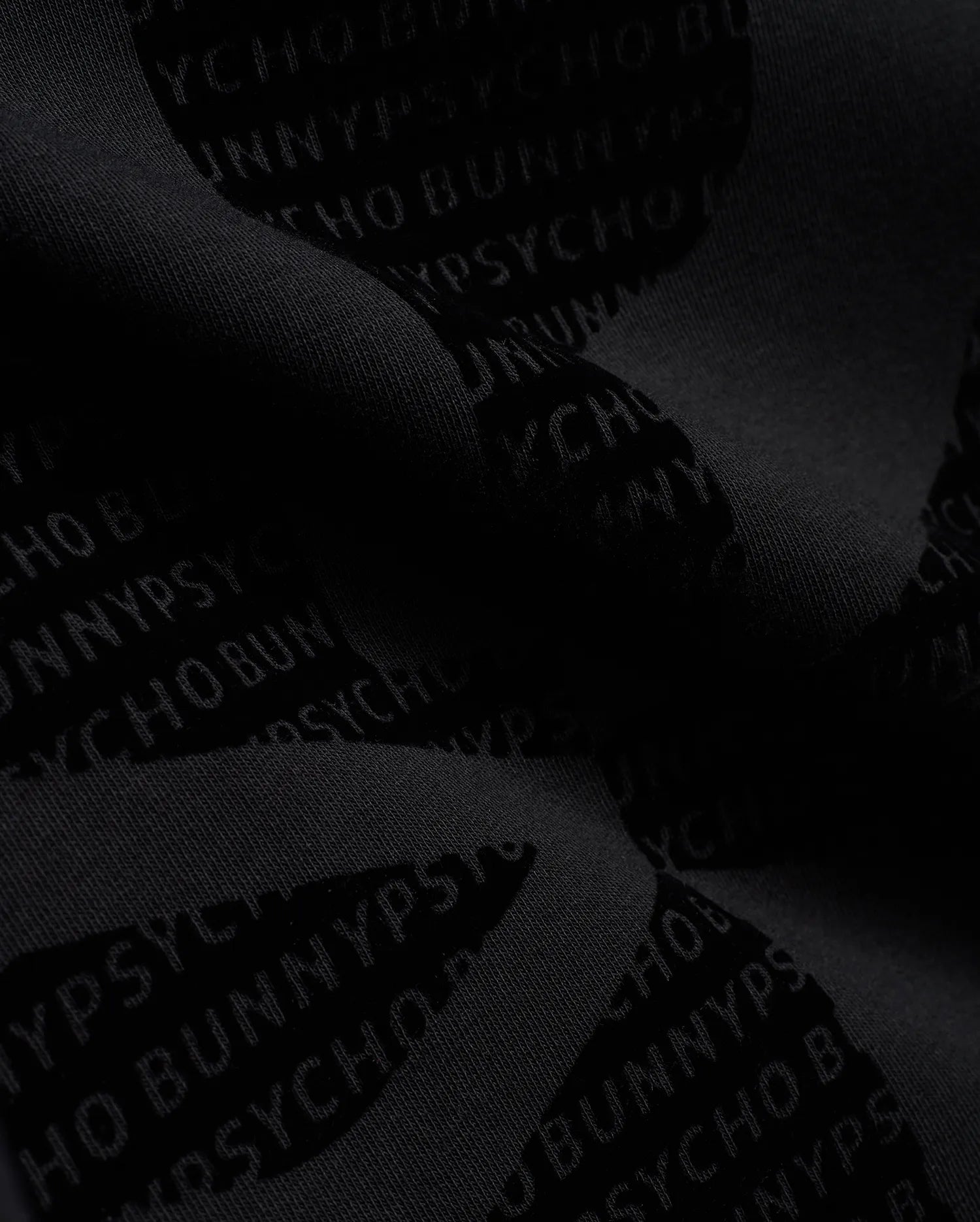 Men's Angus Oversized Crewneck in dark charcoal grey, crafted from soft knit fabric with an allover tonal Psycho Bunny text pattern, embodying refined streetwear. (6)