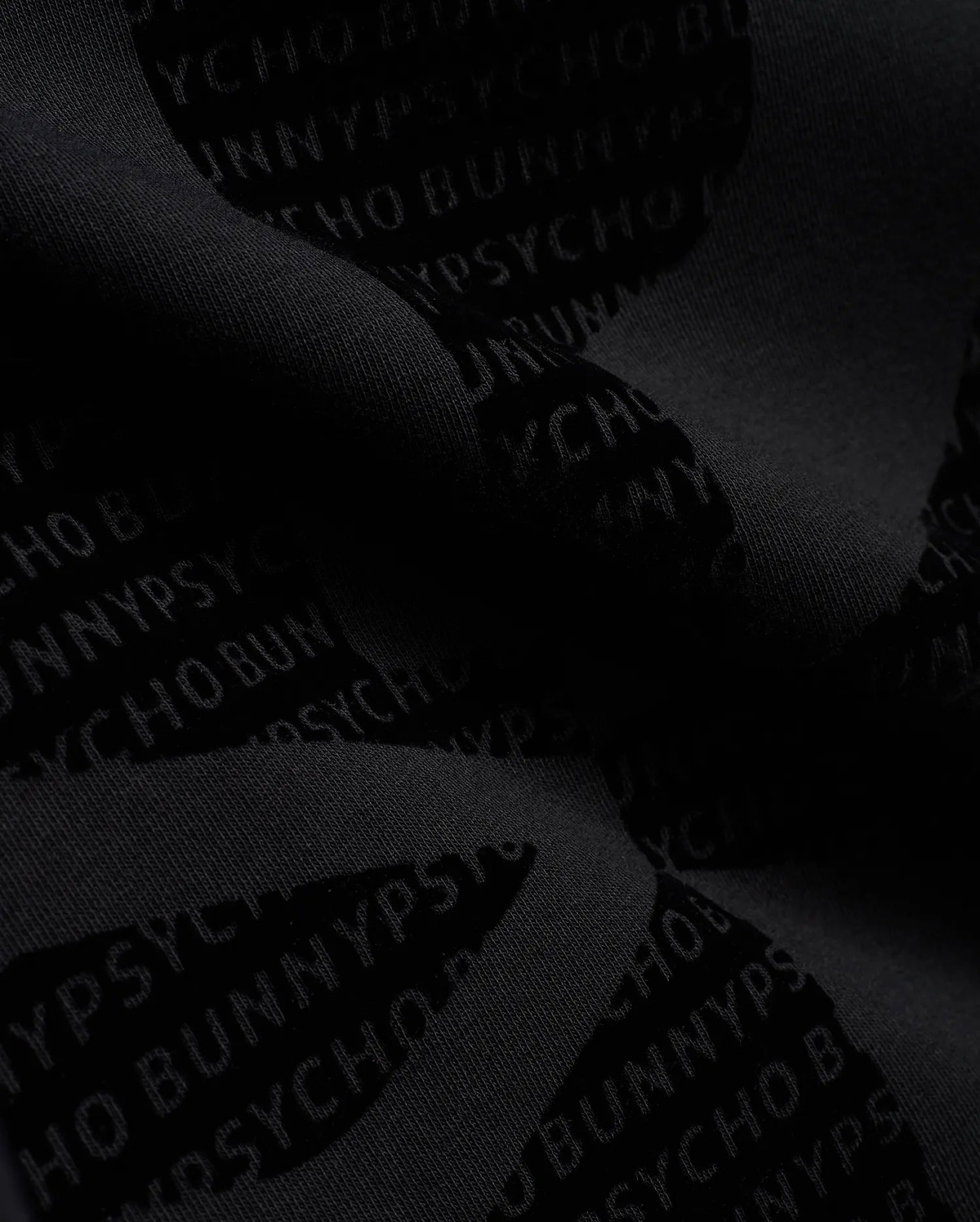 Men's Angus Oversized Crewneck in dark charcoal grey, crafted from soft knit fabric with an allover tonal Psycho Bunny text pattern, embodying refined streetwear. (6)