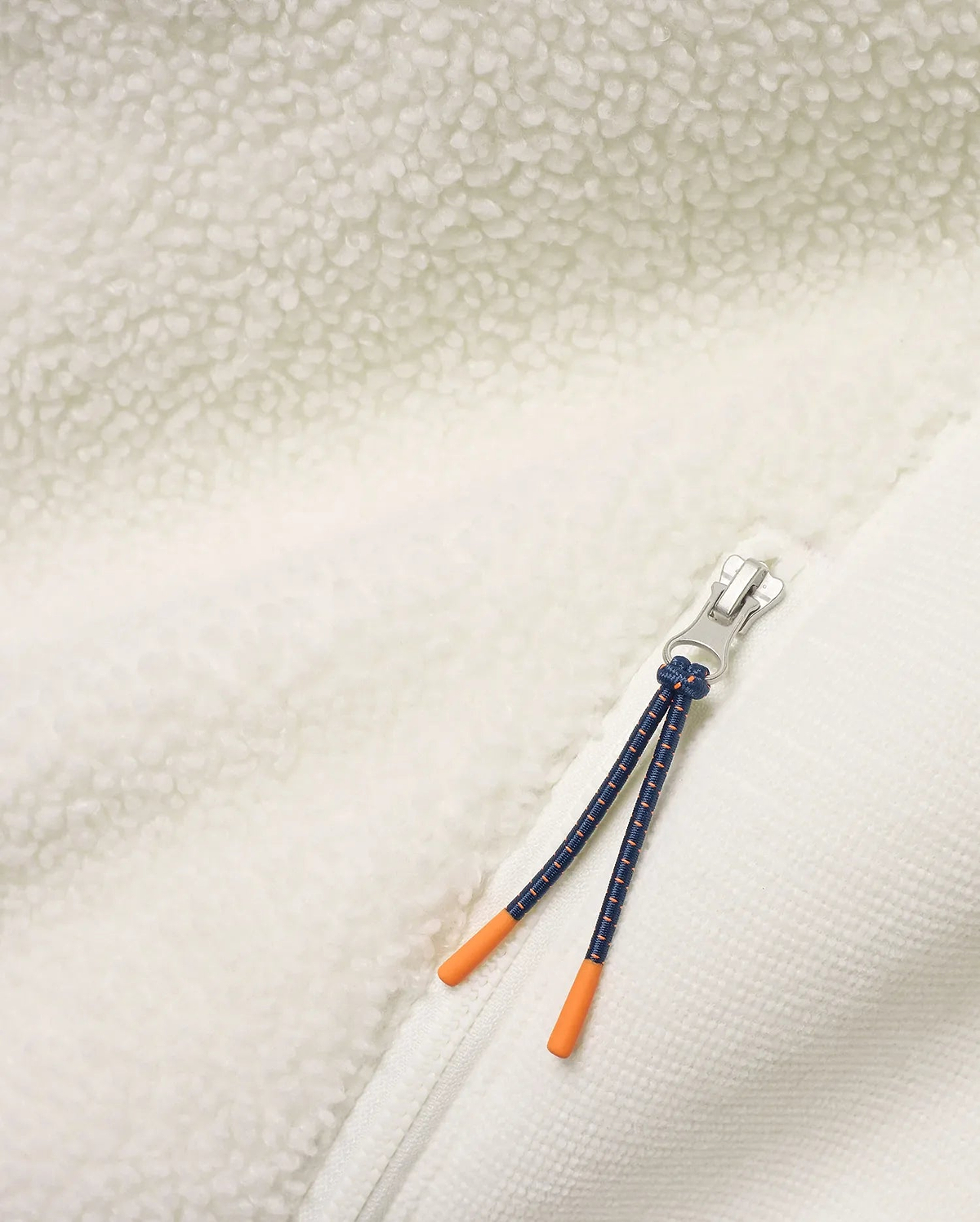 Men's Rowley Sherpa Zip Jacket featuring creamy sherpa fleece and textured knit fabric, a silver zipper, and a navy cord zipper pull with bright orange tips. (6)