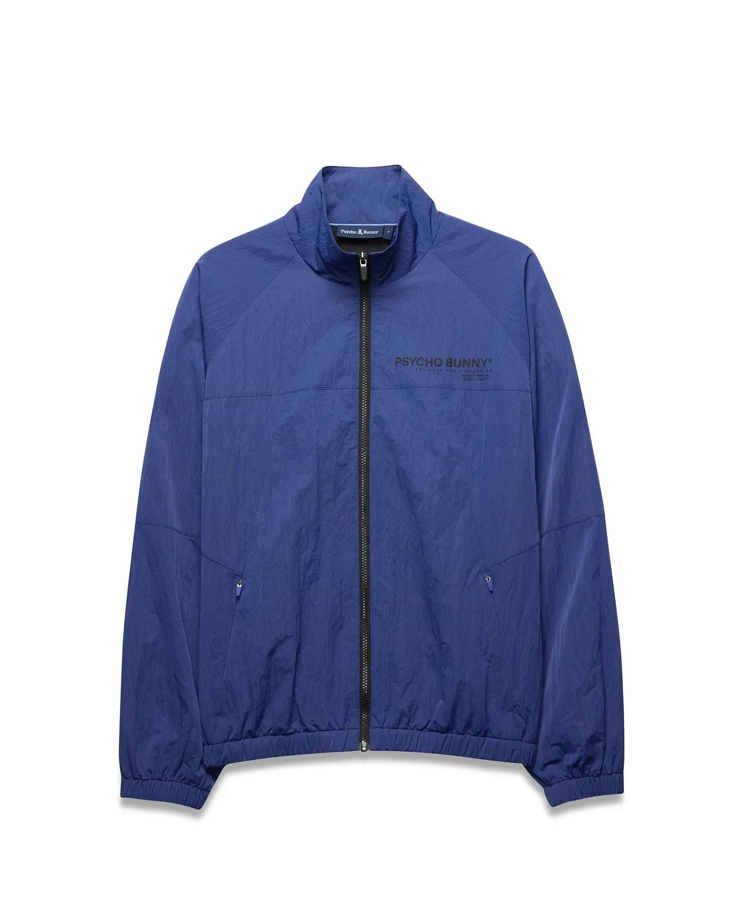 Mens Alder Nylon Jacket, a royal blue full-zip jacket with a crinkled texture, features a stand collar, elastic cuffs/hem, zippered pockets, and a large black PSYCHO BUNNY® DESIGNED FOR DISRUPTION text logo on the chest. (5)