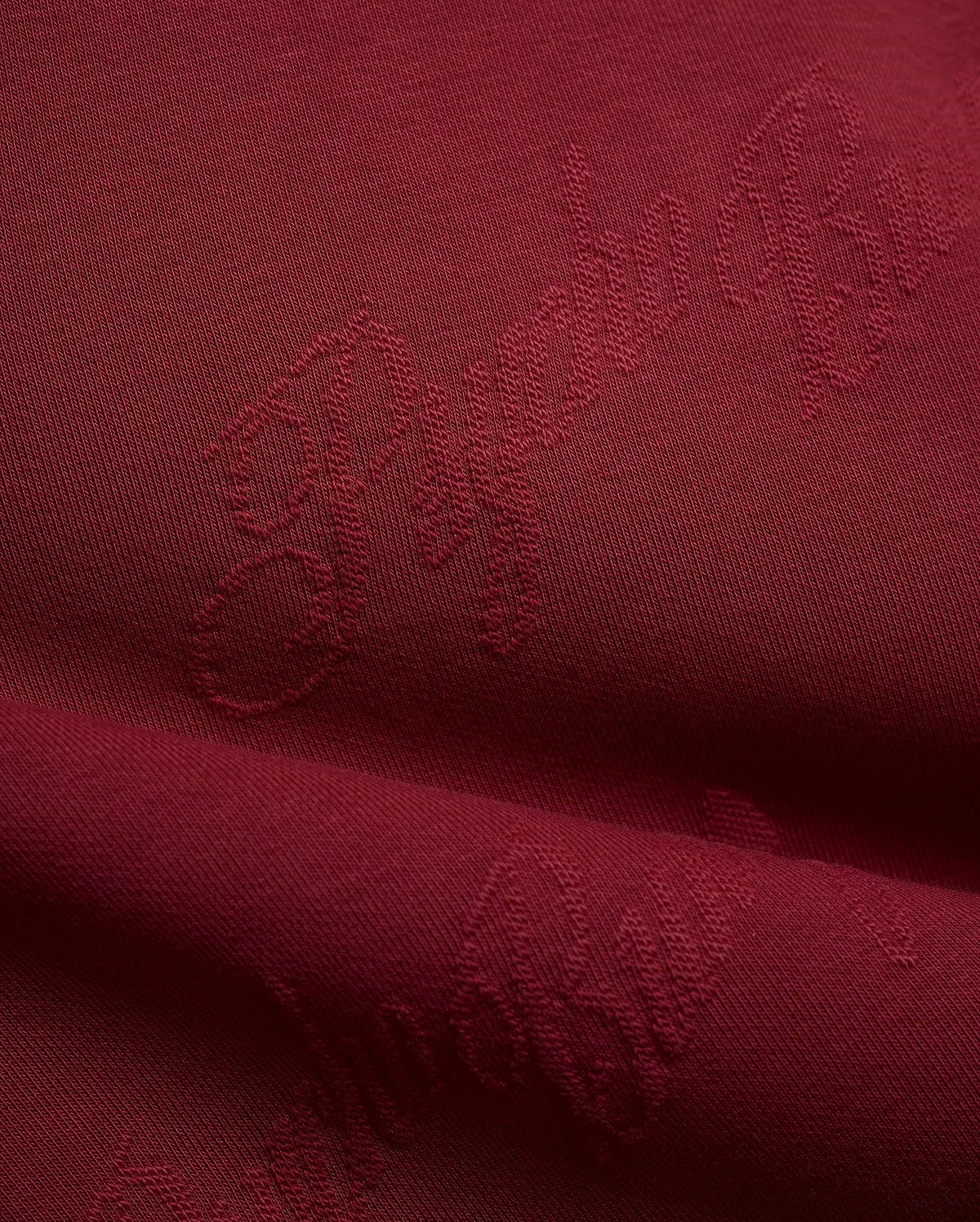 Mens Cedrick All Over Jacquard Crew in deep burgundy, featuring a subtle tone-on-tone jacquard knit pattern of the Psycho Bunny logo and brand name.