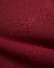 Mens Cedrick All Over Jacquard Crew in deep burgundy, featuring a subtle tone-on-tone jacquard knit pattern of the Psycho Bunny logo and brand name.