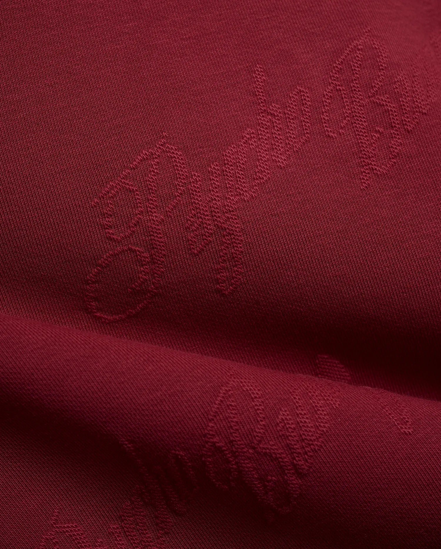 Mens Cedrick All Over Jacquard Crew in deep burgundy, featuring a subtle tone-on-tone jacquard knit pattern of the Psycho Bunny logo and brand name.