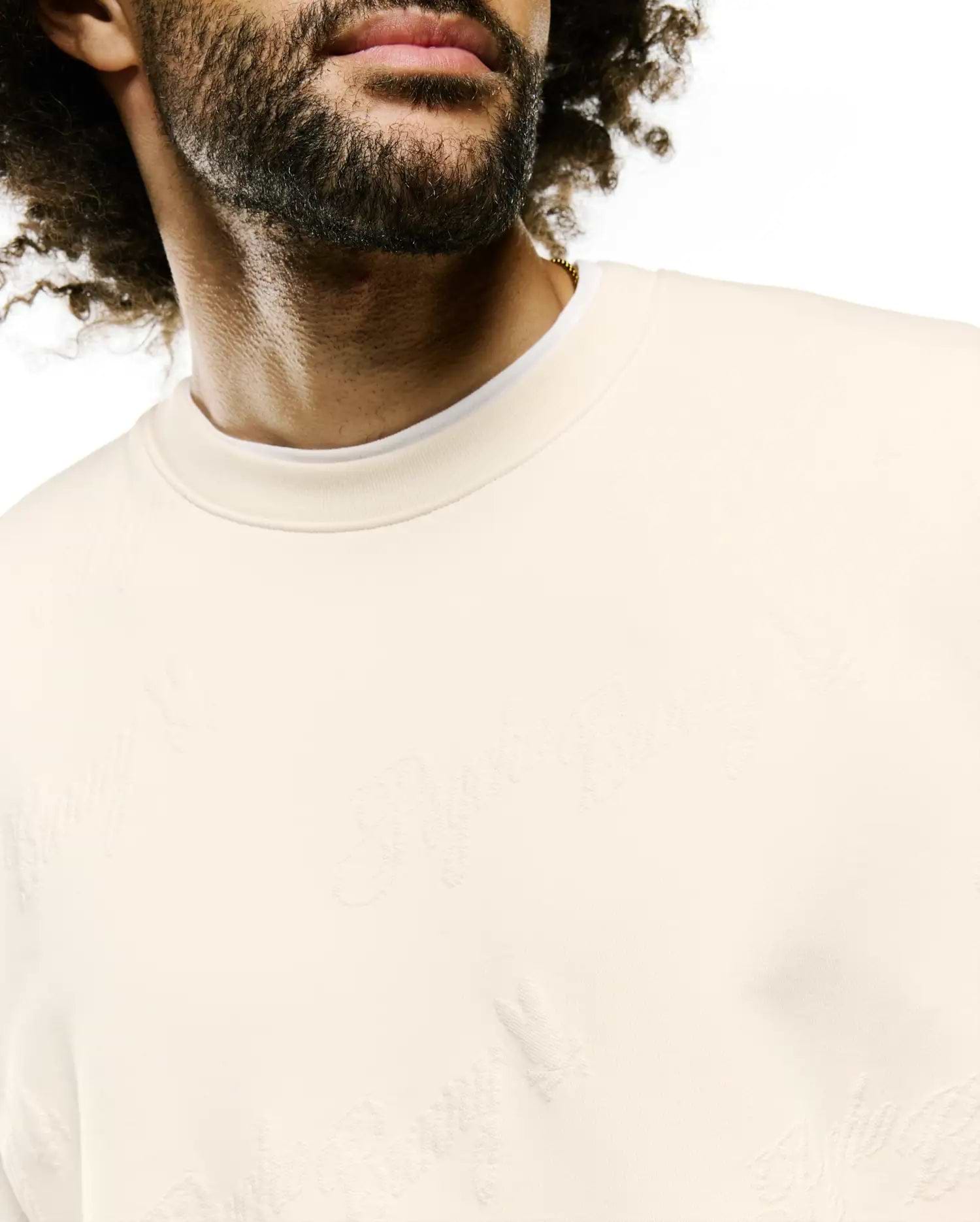 Cream Mens Cedrick All Over Jacquard Crew, a relaxed fit sweatshirt with a subtle tone-on-tone jacquard knit featuring the iconic Psycho Bunny skull logo and brand text throughout.