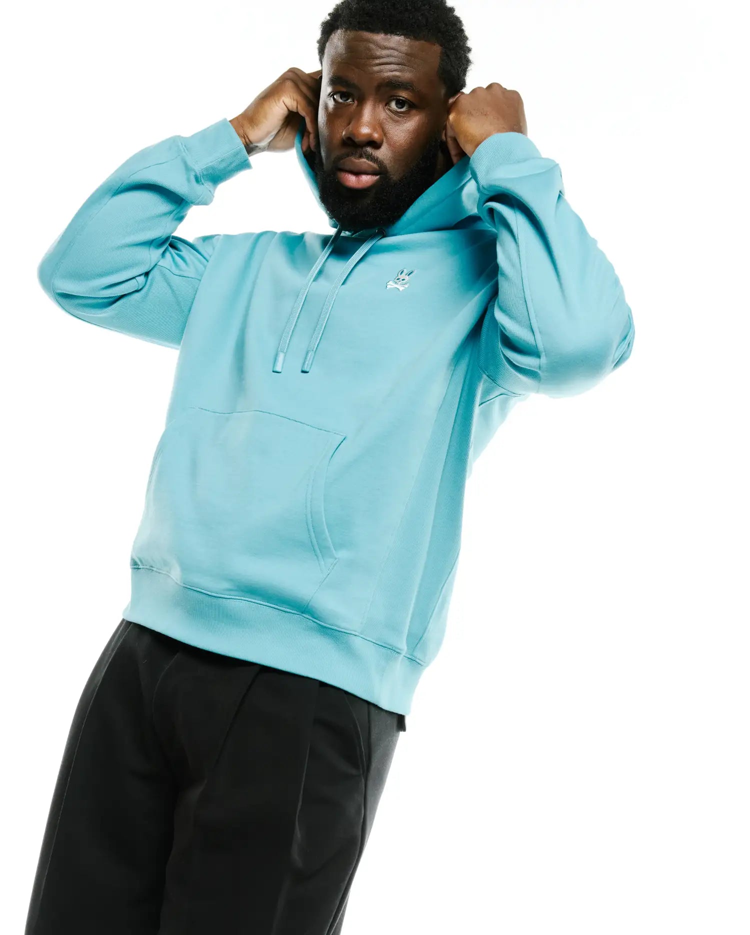Men's Terrence Fleece Hoodie in light blue, featuring a relaxed fit, soft french terry fabric, ribbed cuffs and hem, kangaroo pocket, and a small embroidered white Psycho Bunny skull logo on the left chest. (3)