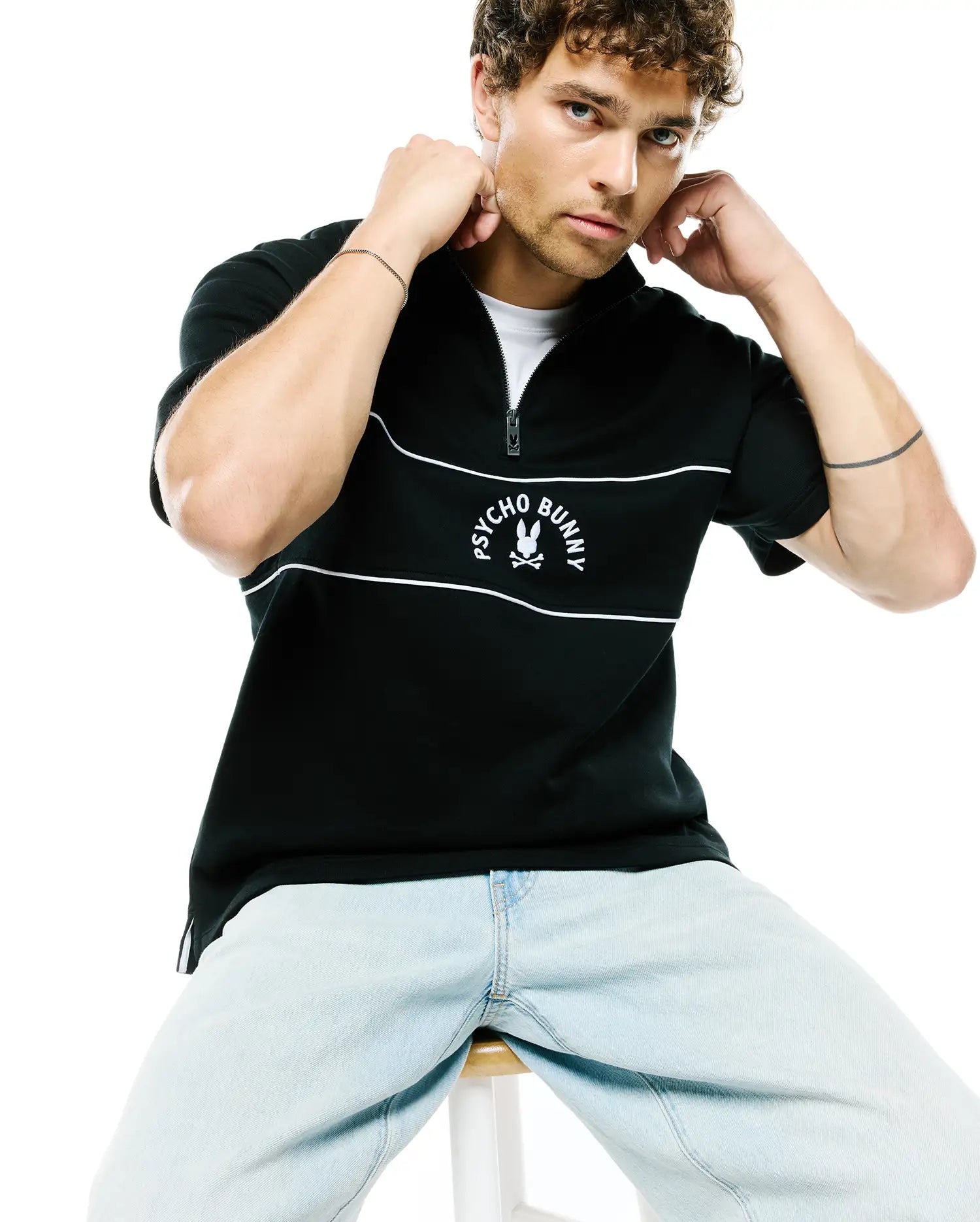 Mens Stevie French Terry Ss 1/4 Zip in black, featuring a classic fit, two white horizontal stripes, and a prominent embroidered white Psycho Bunny skull logo with text on the chest.