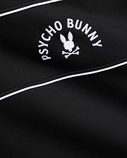 Mens Stevie French Terry Ss 1/4 Zip in black french terry, featuring a prominent white embroidered Psycho Bunny skull logo with curved text and white piping detail.