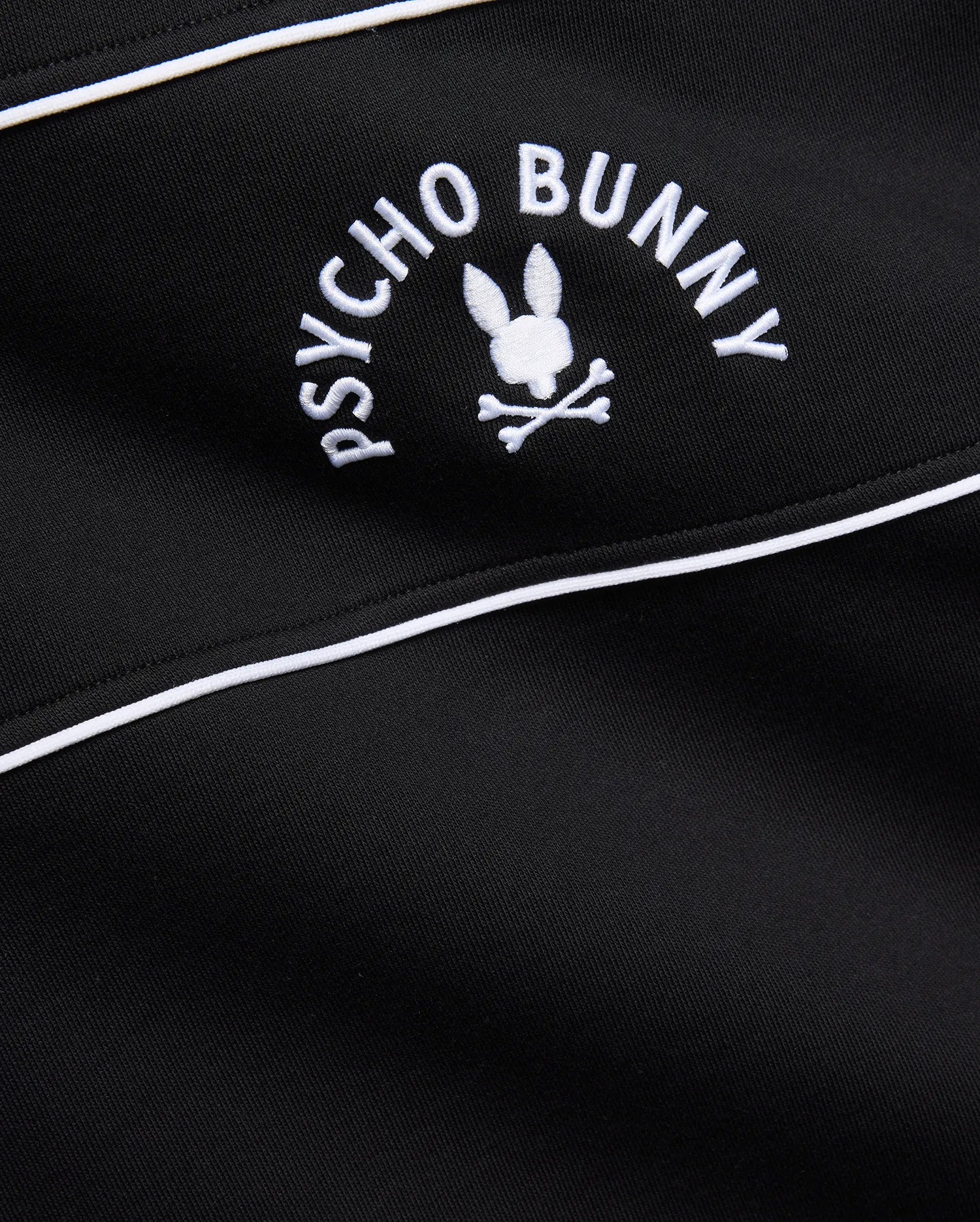 Mens Stevie French Terry Ss 1/4 Zip in black french terry, featuring a prominent white embroidered Psycho Bunny skull logo with curved text and white piping detail.