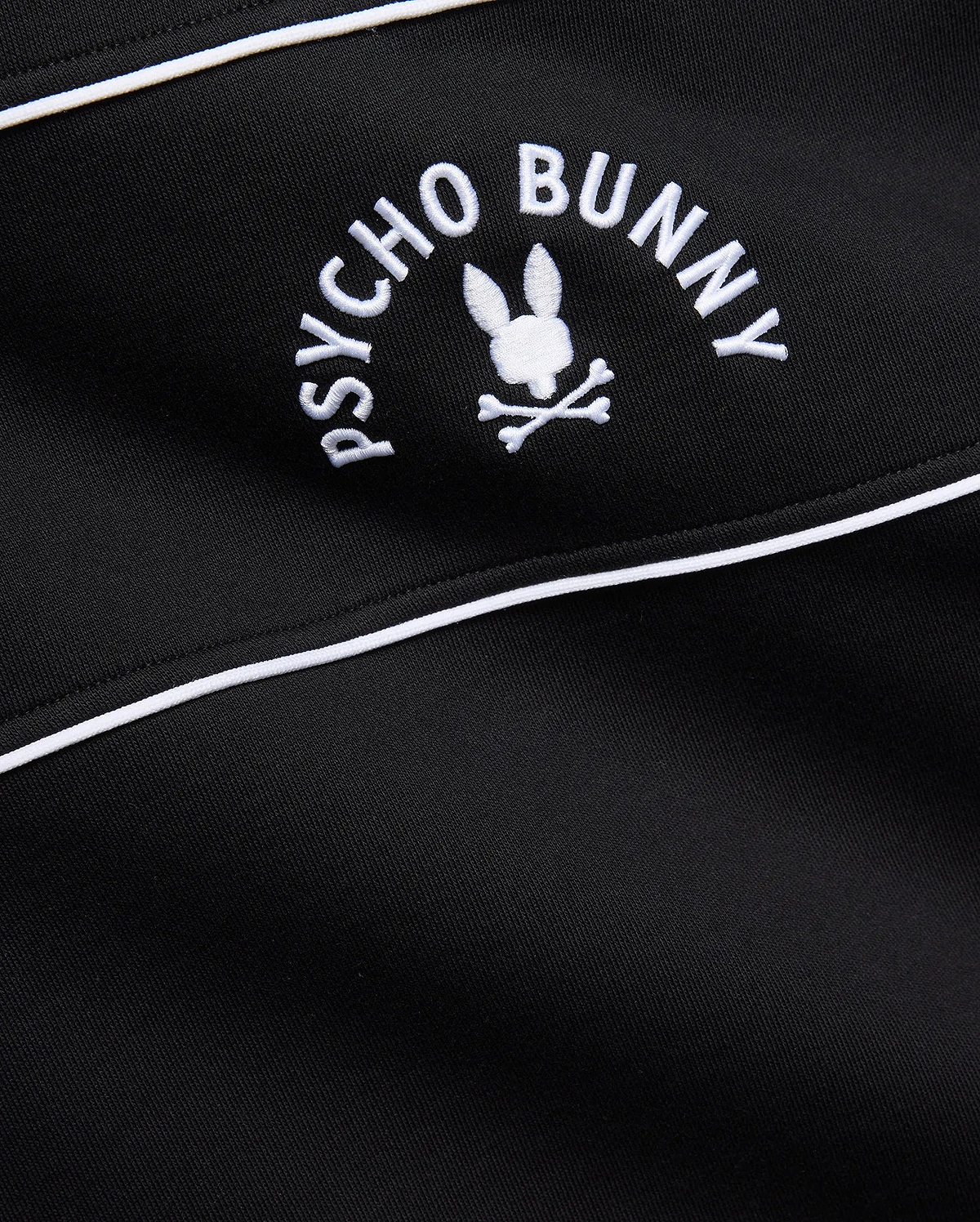 Mens Stevie French Terry Ss 1/4 Zip in black french terry, featuring a prominent white embroidered Psycho Bunny skull logo with curved text and white piping detail.