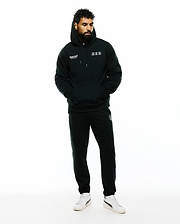 Mens Nathaniel Relaxed Chest Hoodie in black French terry, featuring white Psycho Bunny text and three outlined bunny skull logos on the chest, paired with matching black sweatpants with a small white bunny skull logo on the thigh. (2)