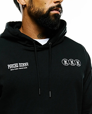 Mens Nathaniel Relaxed Chest Hoodie in black French terry, featuring white Psycho Bunny text and three bunny skull logos on the chest, with hood drawstrings. (4)