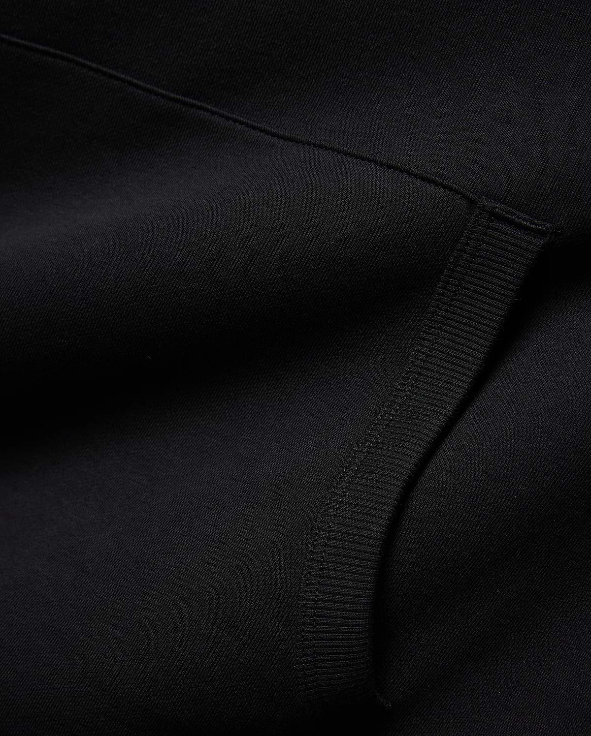 Mens Nathaniel Relaxed Chest Hoodie in deep black, crafted from a soft knit fabric with a subtle diagonal texture and a prominent ribbed cuff detail. (6)