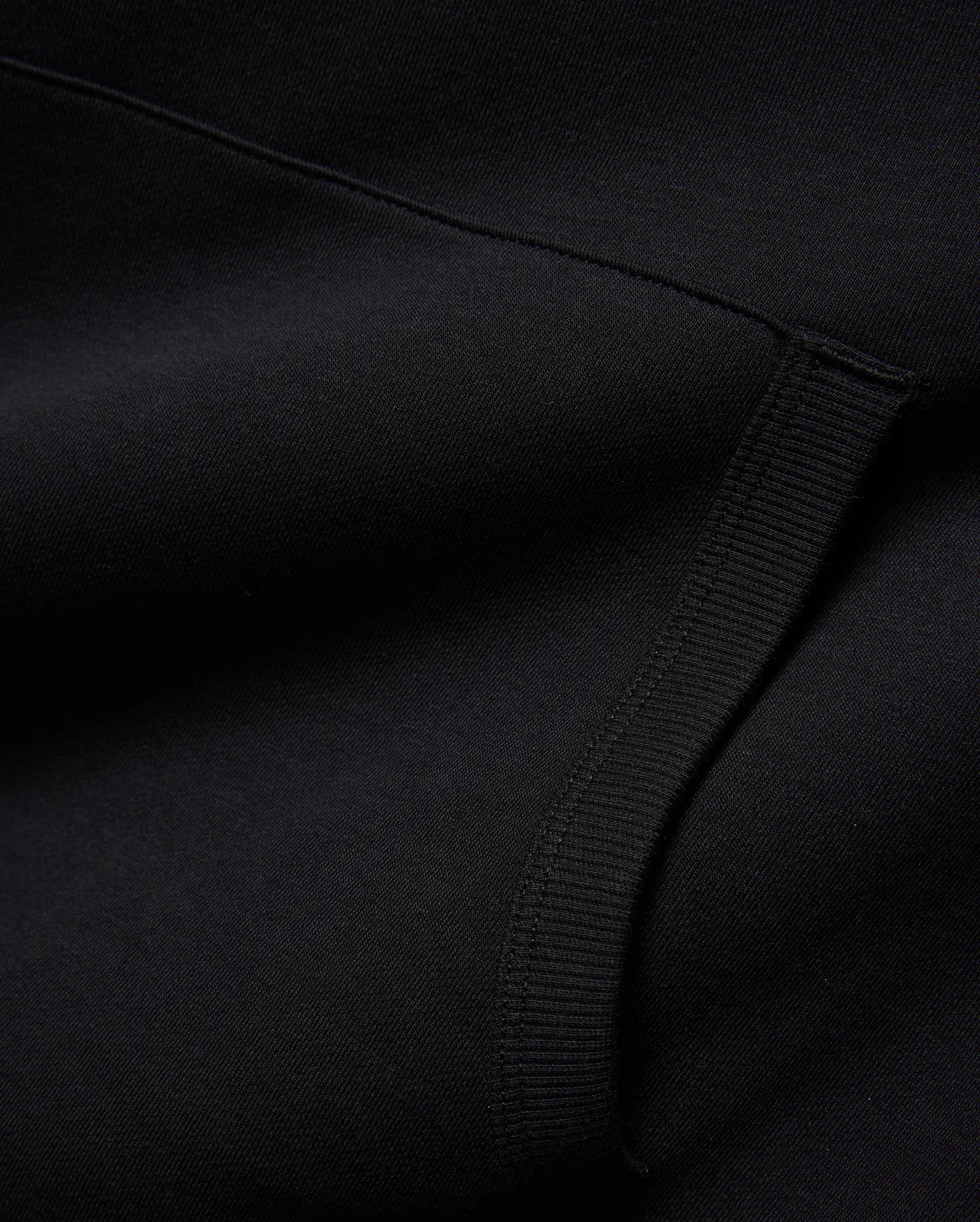 Mens Nathaniel Relaxed Chest Hoodie in deep black, crafted from a soft knit fabric with a subtle diagonal texture and a prominent ribbed cuff detail. (6)