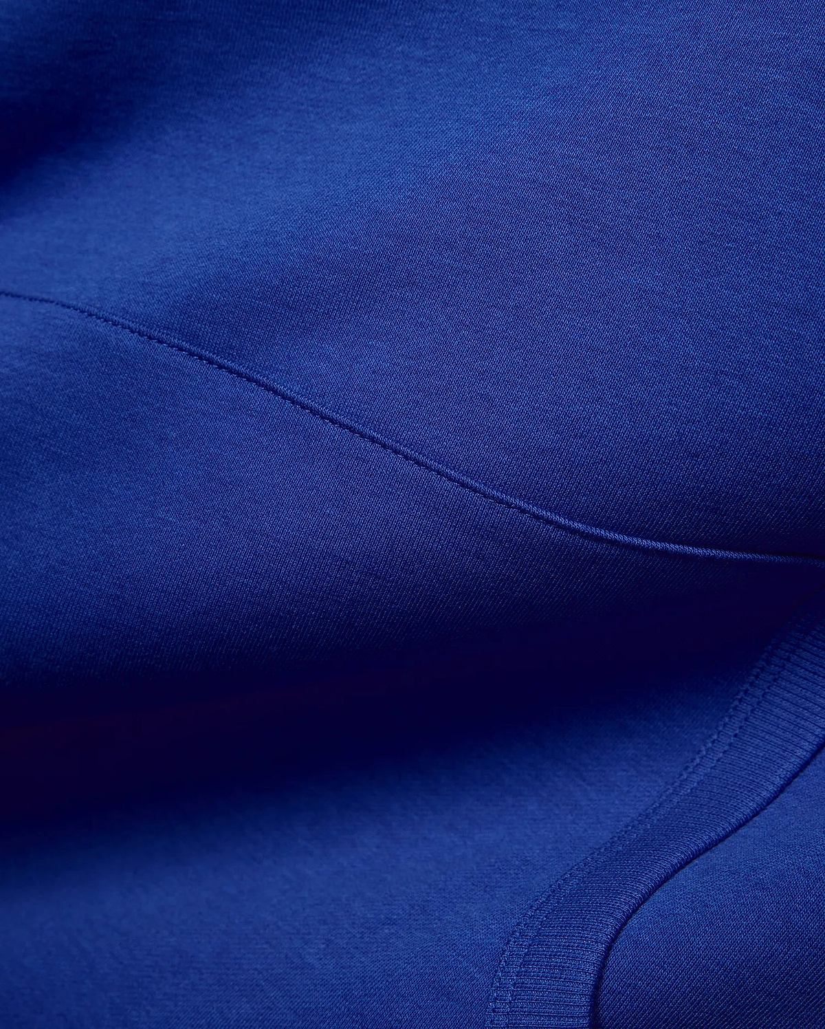 Vibrant royal blue Mens Nathaniel Relaxed Chest Hoodie, crafted from soft jersey fabric with visible seam stitching and a ribbed hem detail, embodying refined streetwear. (6)