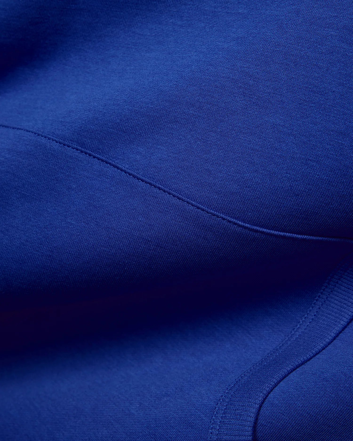 Vibrant royal blue Mens Nathaniel Relaxed Chest Hoodie, crafted from soft jersey fabric with visible seam stitching and a ribbed hem detail, embodying refined streetwear. (6)