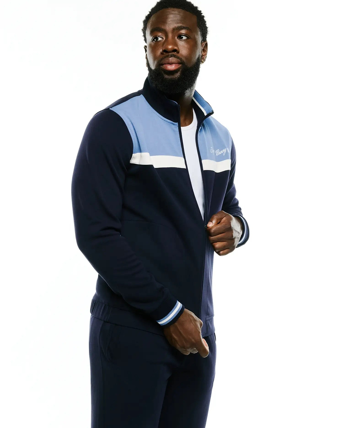 Men's Jacques Pique Track Jacket in navy with light blue and white color block panels, full zip, ribbed cuffs, and an embroidered Psycho Bunny script logo on the left chest. (2)
