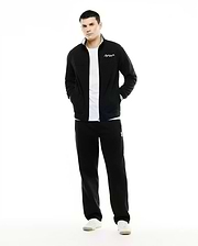 Men's Jacques Pique Track Jacket in black, classic fit, with white collar lining, striped cuffs, and embroidered script logo. Paired with black relaxed fit sweatpants featuring an embroidered bunny skull logo. (1)
