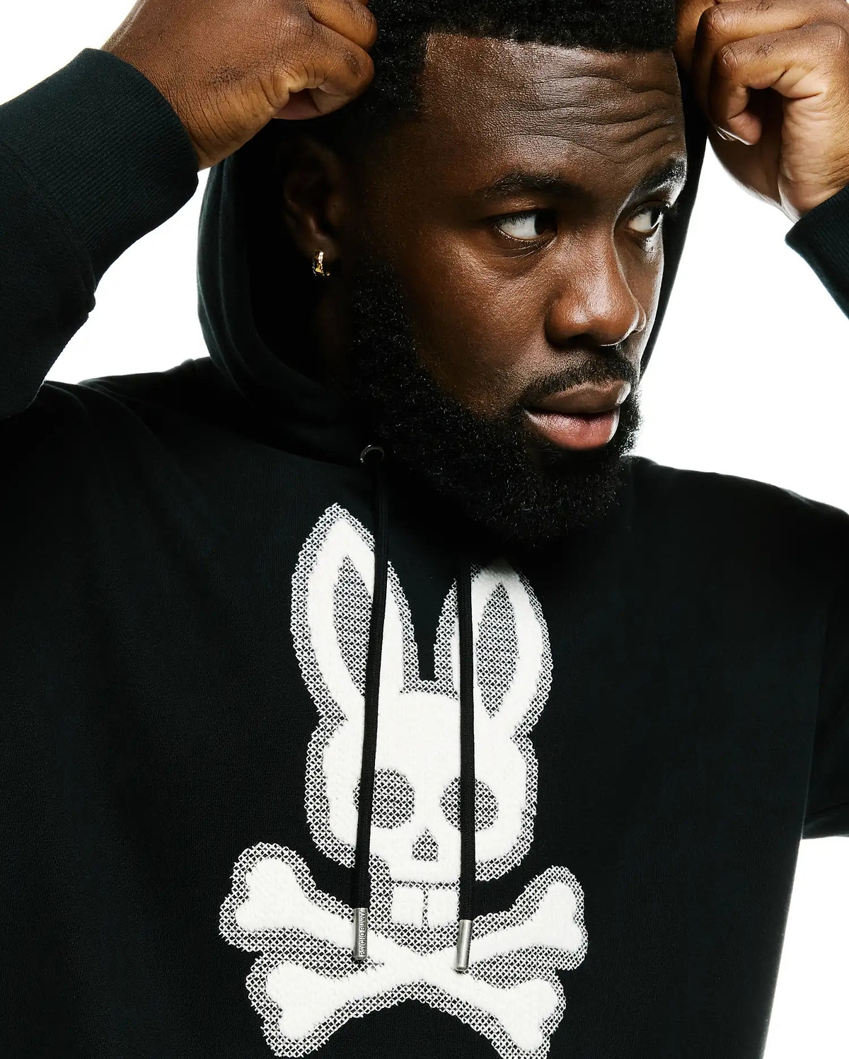 Men's Samson Cotton Hoodie, a black French terry hoodie with a large, central white embroidered Psycho Bunny skull and crossbones logo featuring a textured outline and solid fill, complete with black drawstrings and silver tips. (2)
