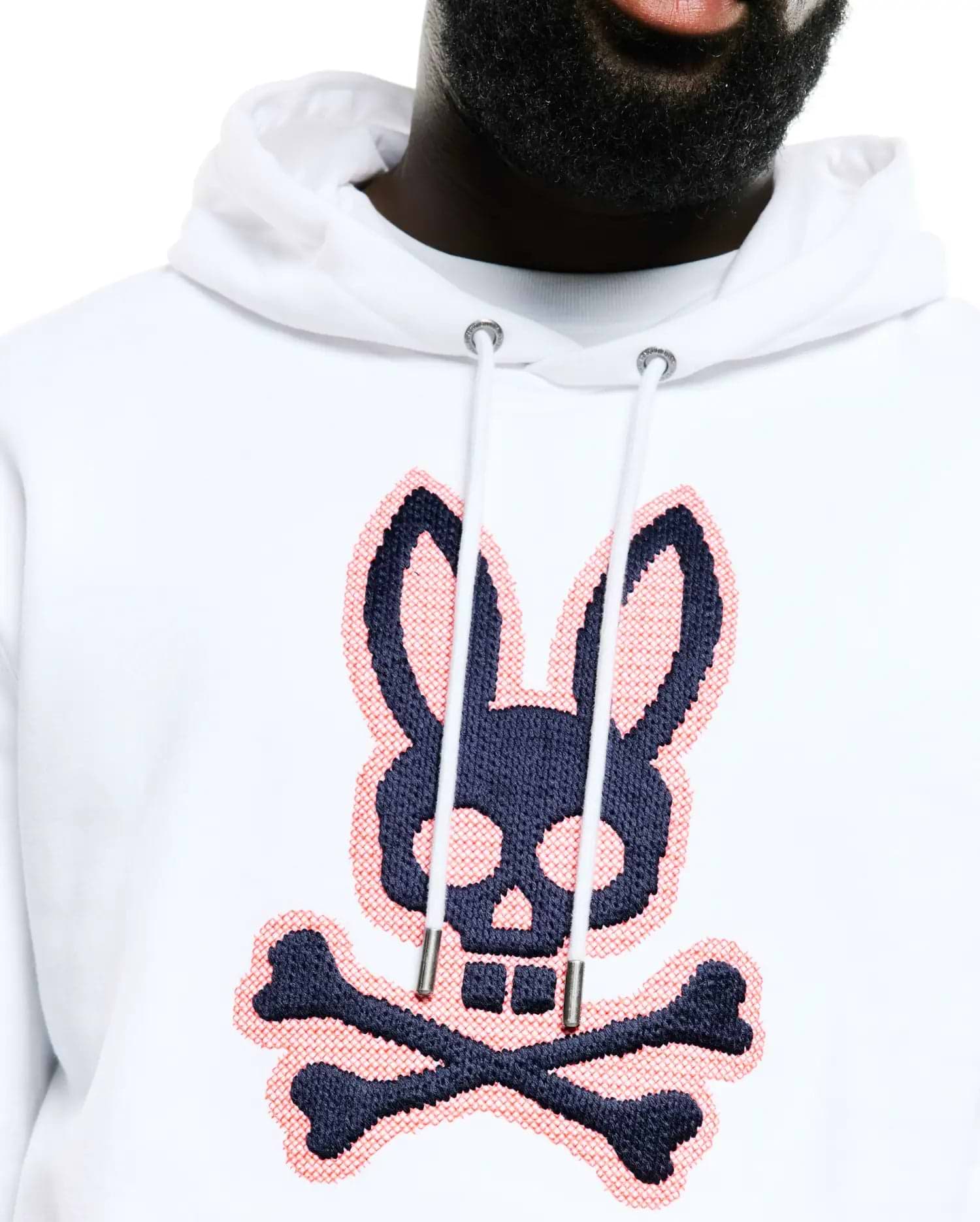 Men's Samson Cotton Hoodie, a white relaxed fit cotton French terry hoodie featuring a large, central navy and coral pink cross-stitch embroidered Psycho Bunny skull and crossbones logo. (2)