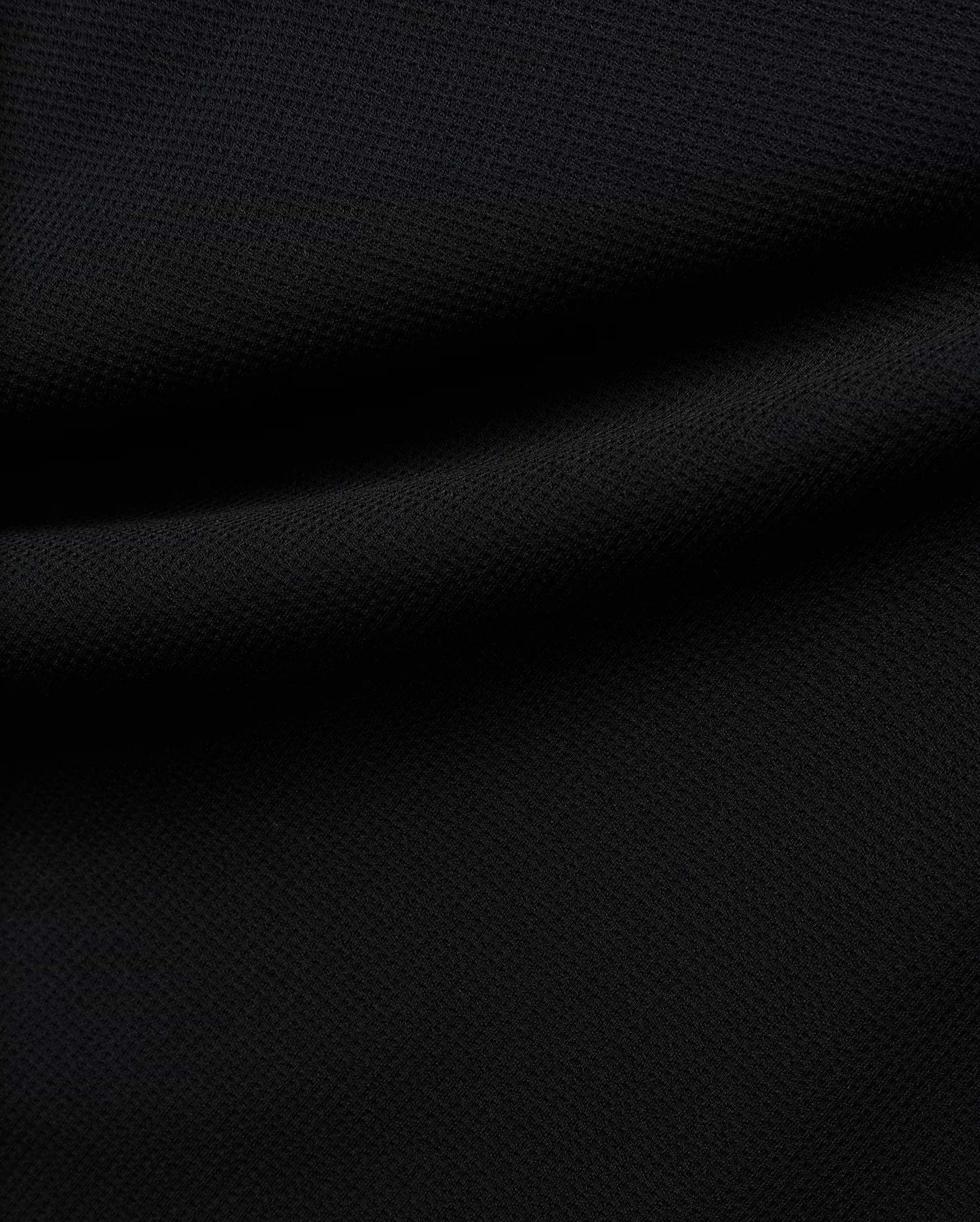 Premium black Tomas Waffle 1/4 Zip, showcasing its rich, deep black fabric with a prominent, textured waffle knit pattern and soft, flowing folds, embodying Psycho Bunny's refined streetwear.