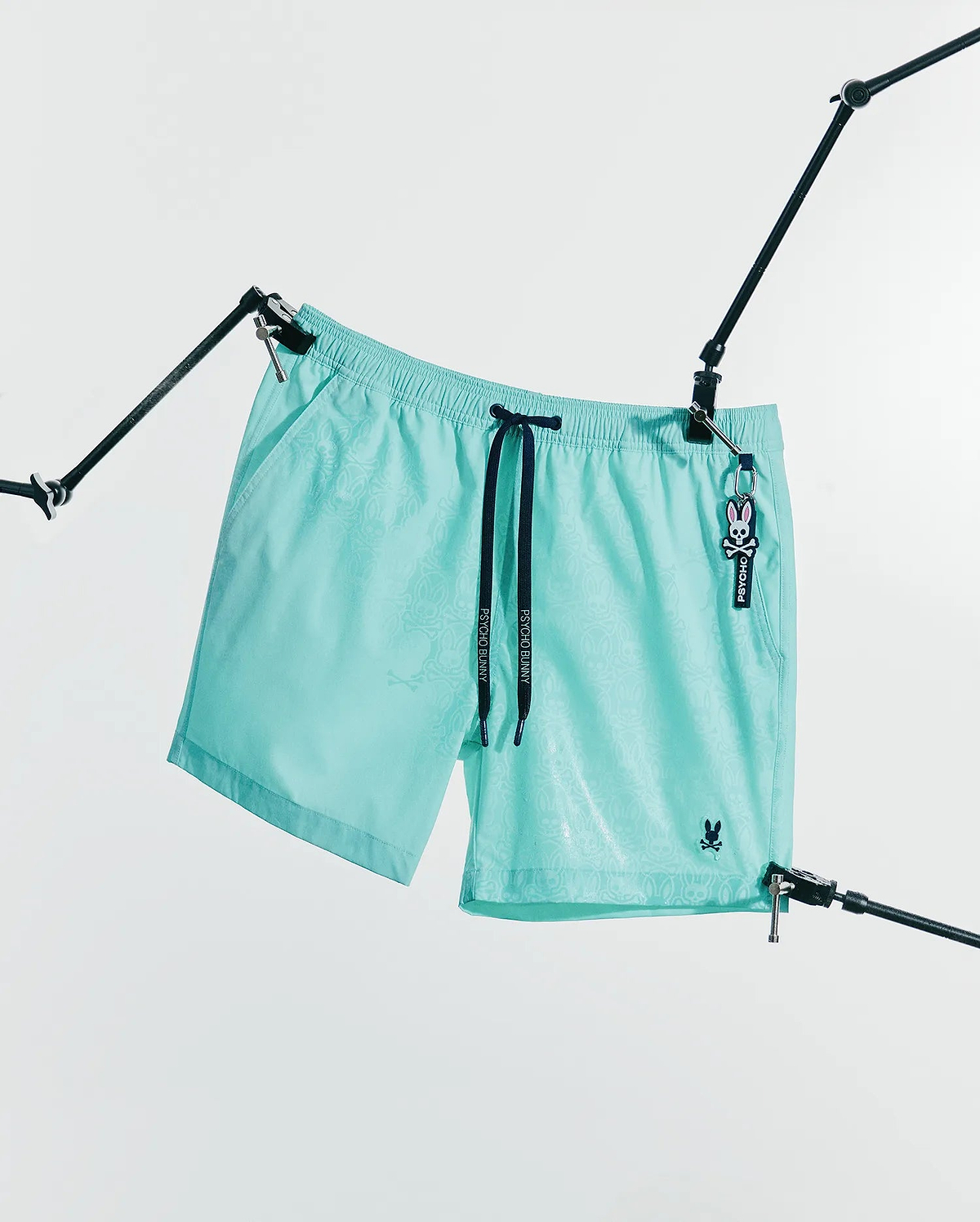 Mens Samos Hydrochromic Printed Swim Trunk 6 in aqua, featuring a subtle hydrochromic bunny skull print, black Psycho Bunny drawstrings, and an embroidered bunny skull logo. (6)