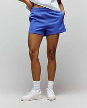 Womens Olivia Fleece Short in vibrant blue, featuring a relaxed fit, soft fleece texture, elastic waistband, and a small embroidered Psycho Bunny skull logo on the left hem.