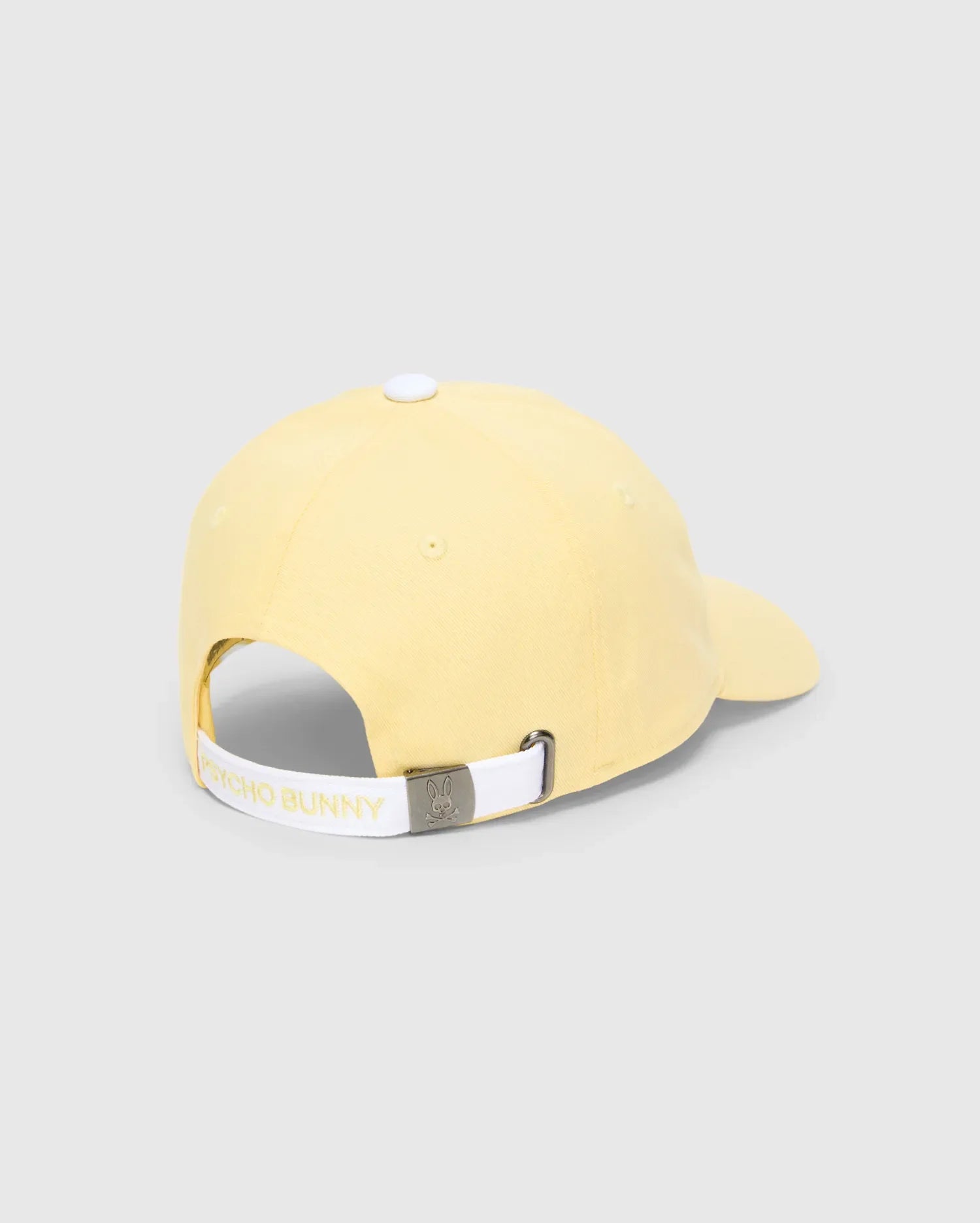 WOMEN'S AMARIS BASEBALL CAP in pale yellow, featuring a smooth cotton twill, white top button, and an adjustable white back strap with Psycho Bunny text and a silver bunny skull logo buckle.